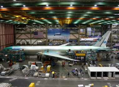 Unidentified Boeing employees continue work building a Boeing 777 jets at its Everett factory, including for KLM Royal Dutch Airlines with a Boeing 787 behind.